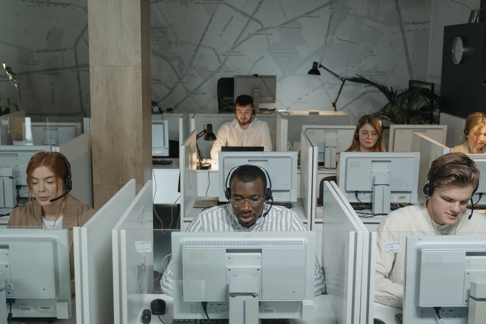 multiple employees on their computers with a headset on 