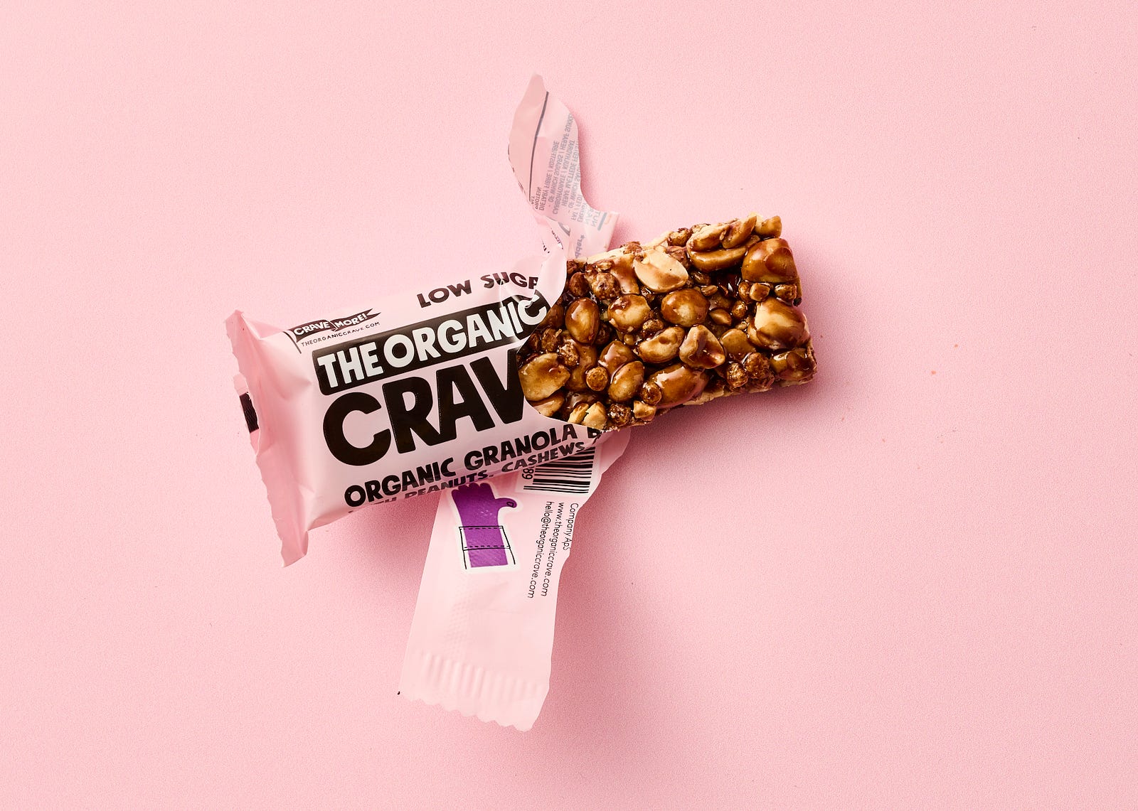 Ahalf open protein bar sits against a light pink background. The global protein bar market was valued at US$ 3.4 Billion in 2022. The market is growing, with a rise of 5.5 percent projected for 2023 to 2028. The COVID pandemic has altered buying patterns. The consumer is moving from conventional brick-and-mortar distribution channels towards online retail platforms to buy protein bars.