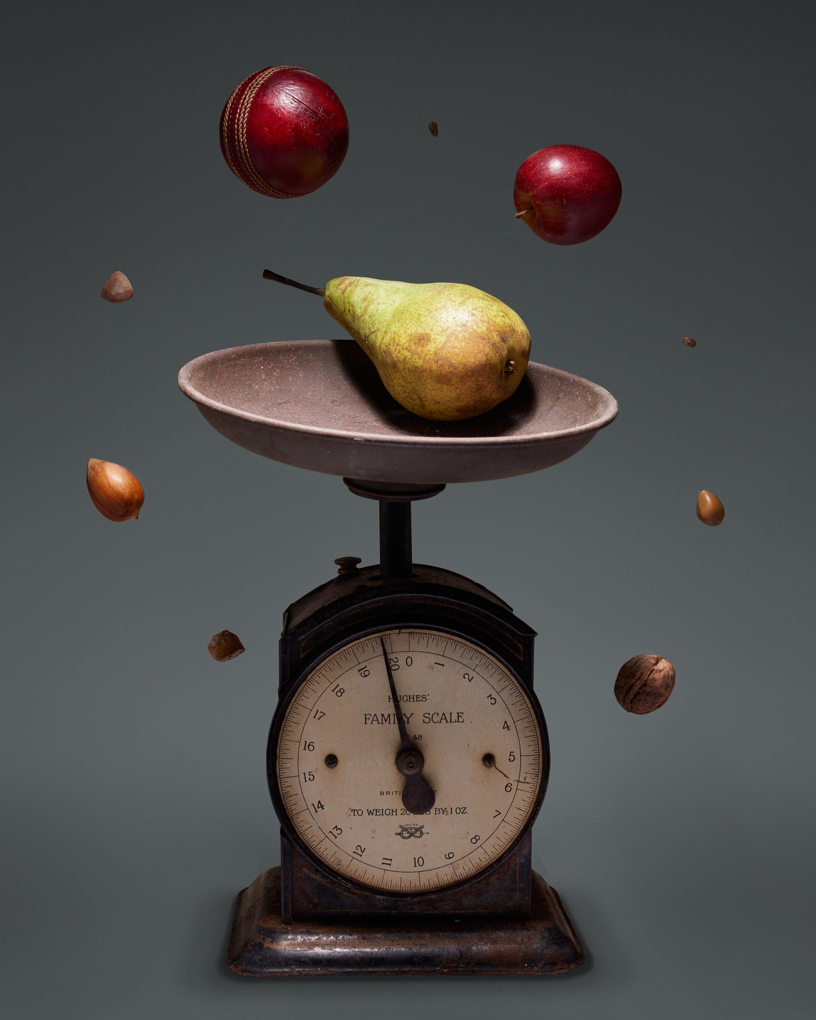 A pear sits on an old-fashioned scale. Dietary or calorie restriction (DR, CR) is reduced food intake without malnutrition.