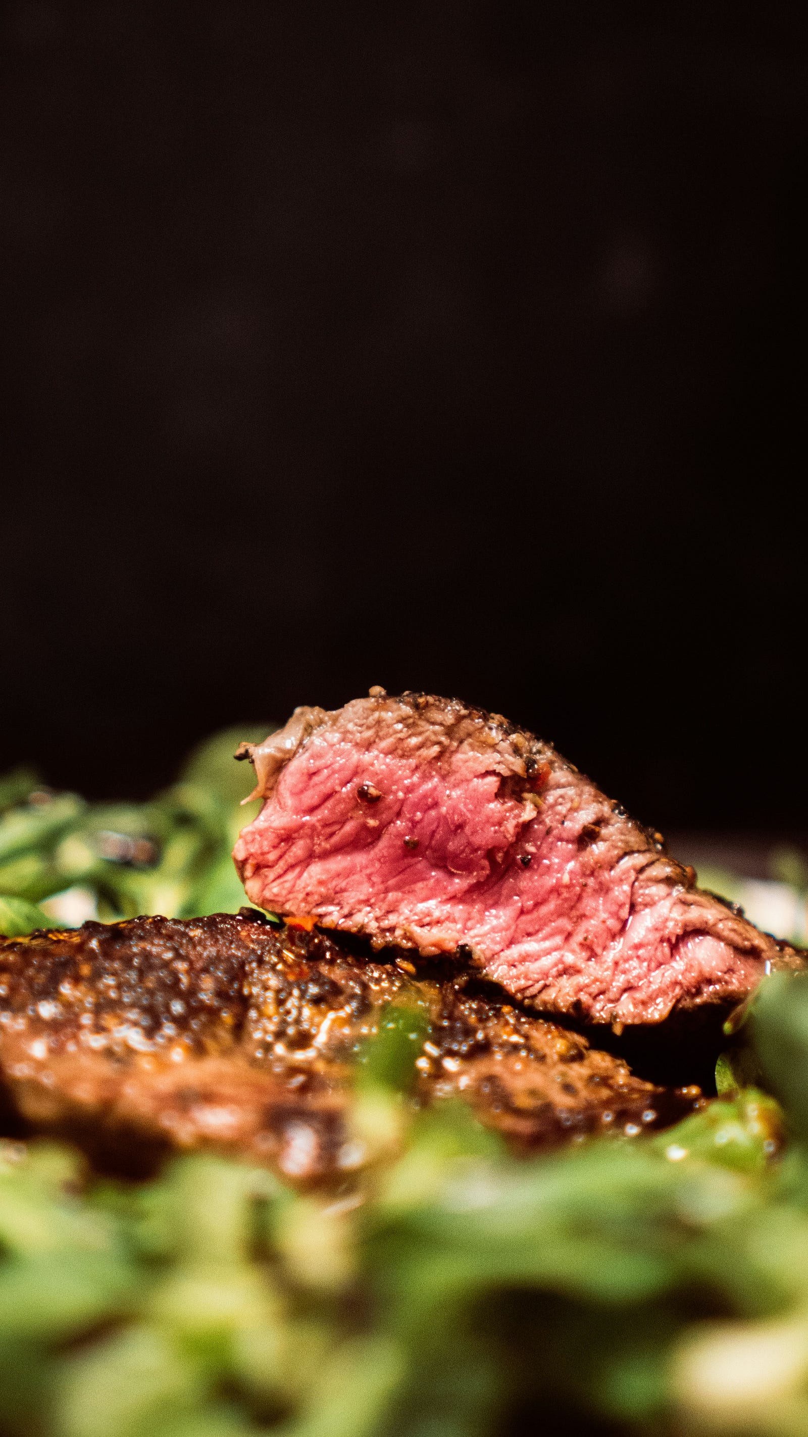 A piece of cooked steak, cut to show us its slightly pink center.