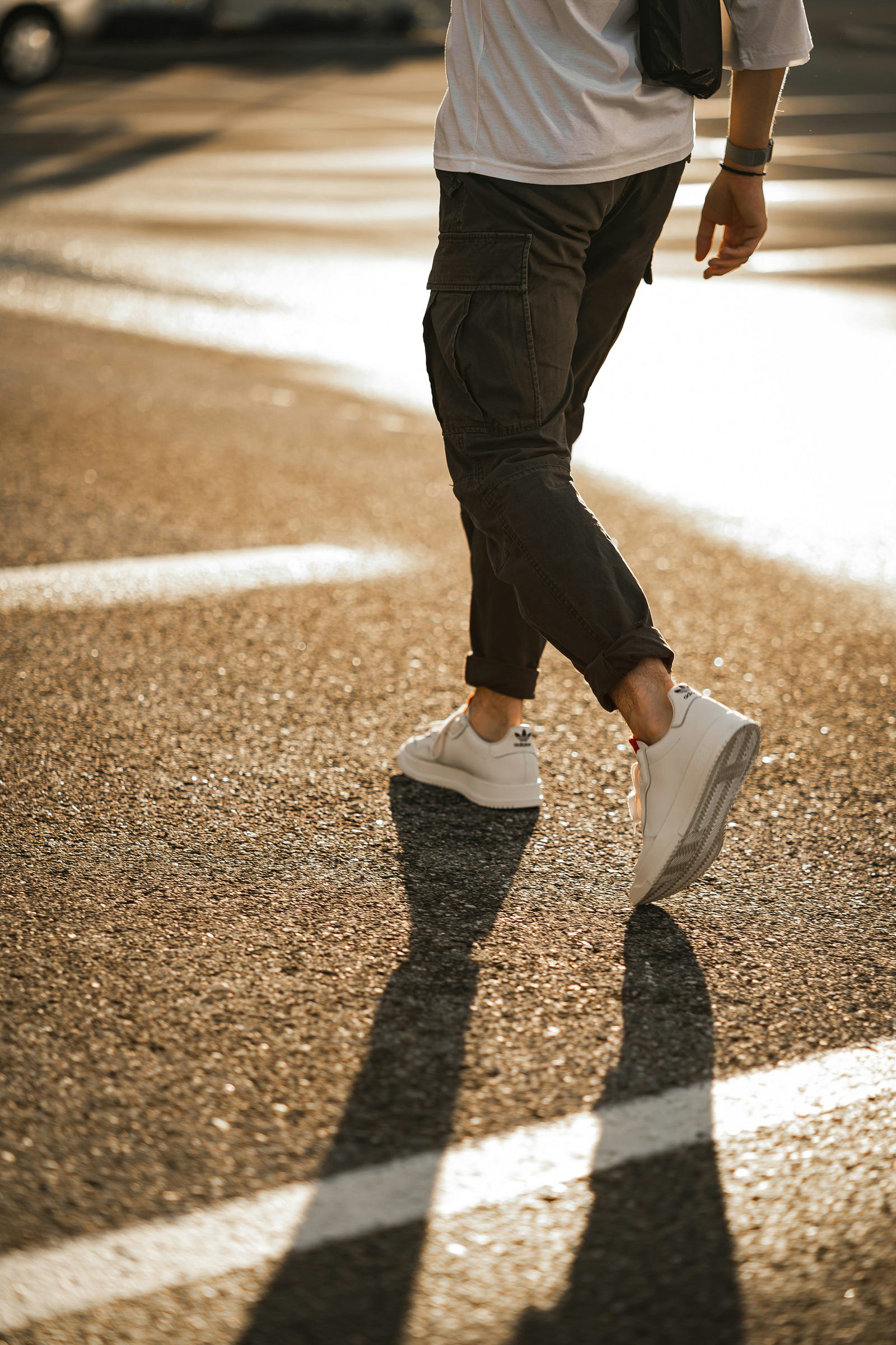 A person walks away from us, using walking as a physical activity.