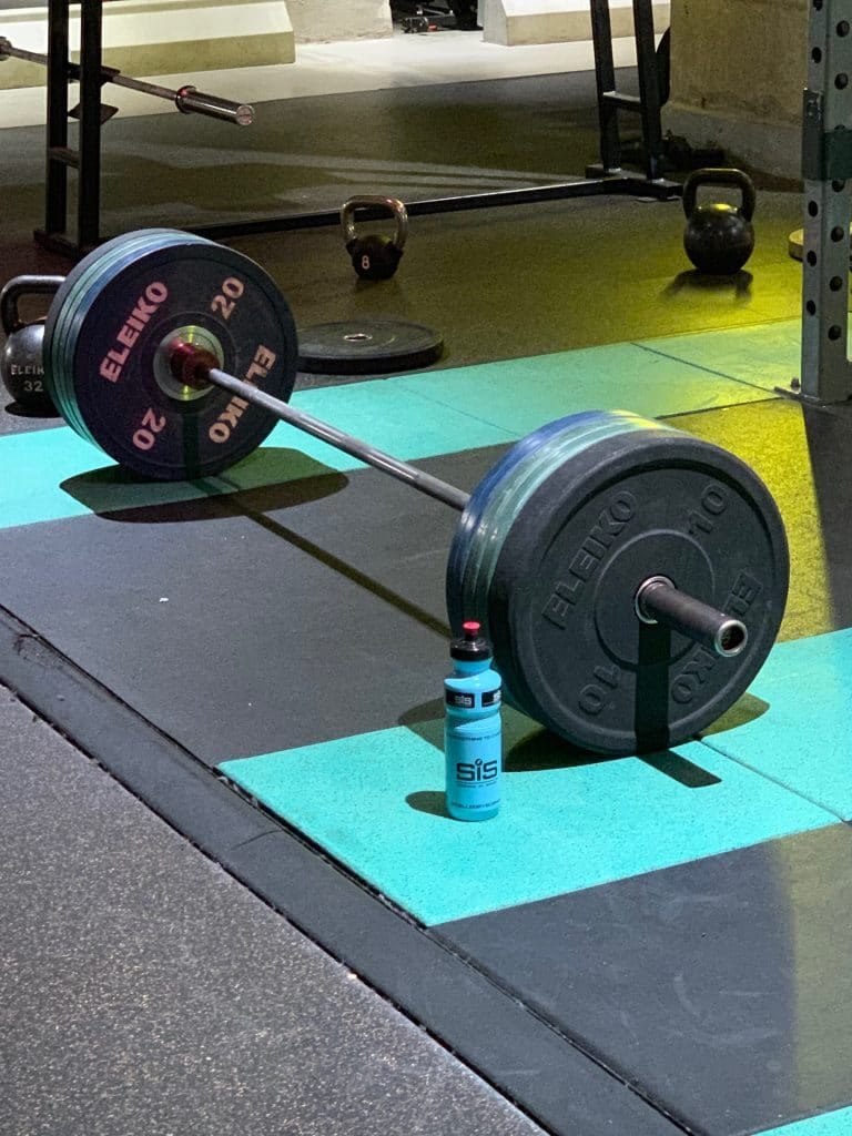 Iron discipline - deadlift bar loaded with heavy plates ready for tough lifting session