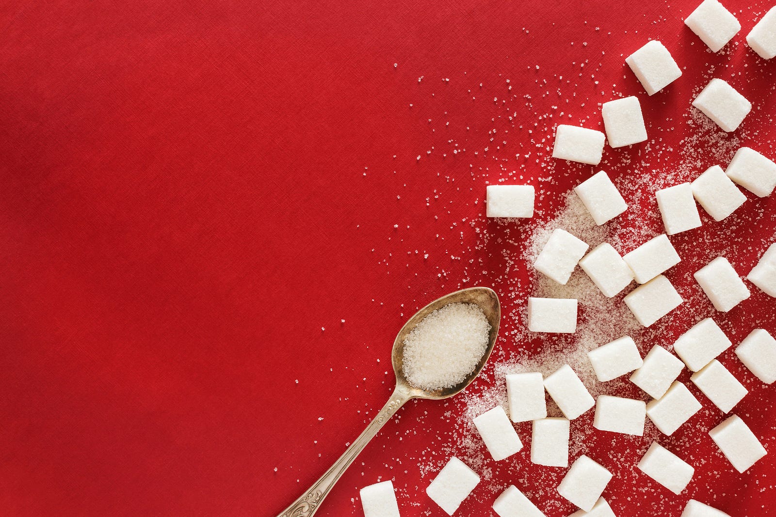 Sugar cubes against a red background.