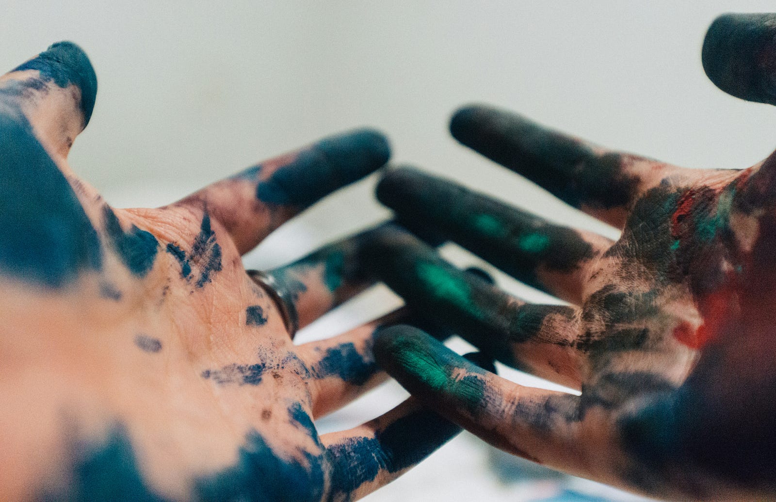 A person with carious colors of paint on their palms and fingers. Paint strippers have the chemical methylene chloride.