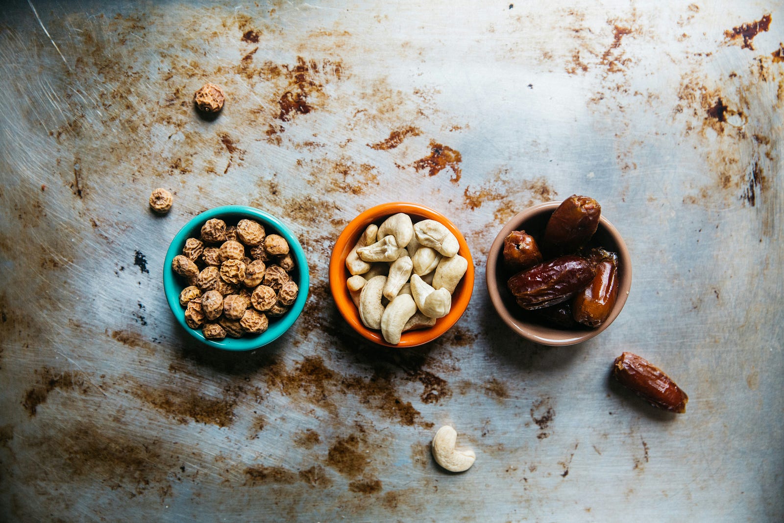 Three small bowls of nuts, aligned horizontally. Nuts can provide potassium.