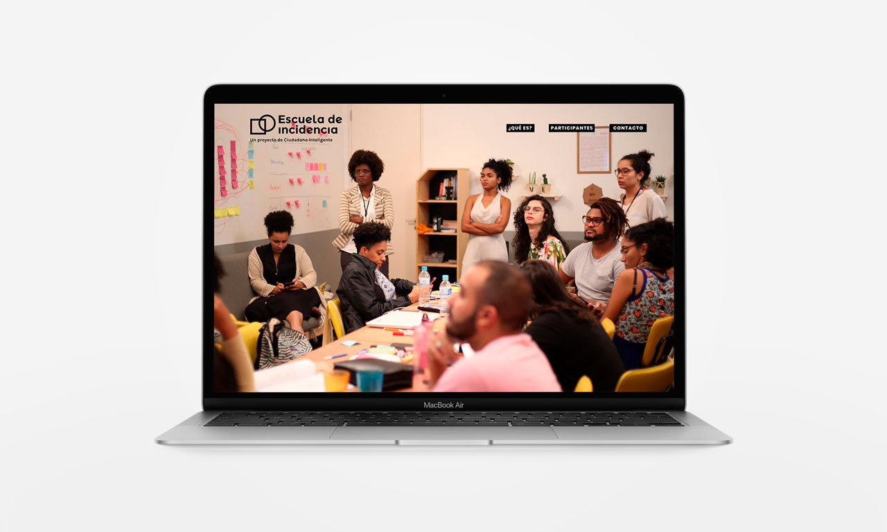 A laptop showing an image of several people sitting around a table indoors.