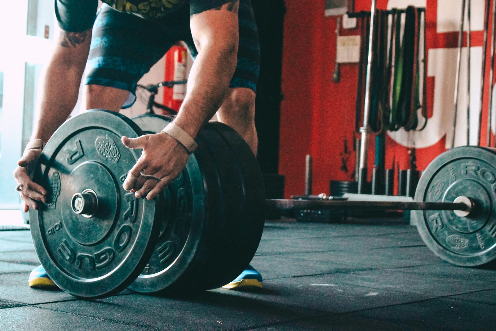 Man adjusts a weight on a barbell.