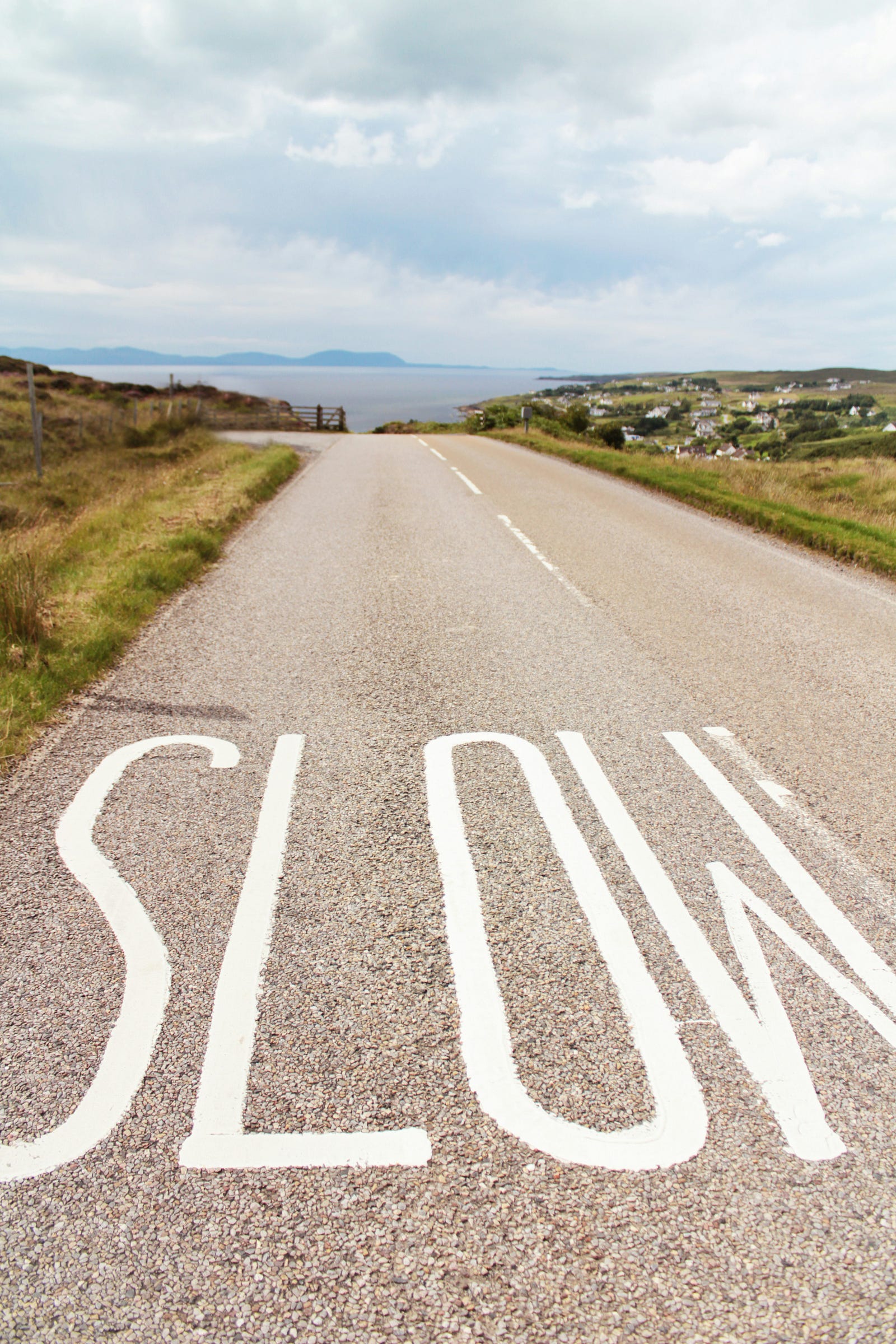 A sign on the road reads “SLOW,” a reminder to start your walking routine slowly.