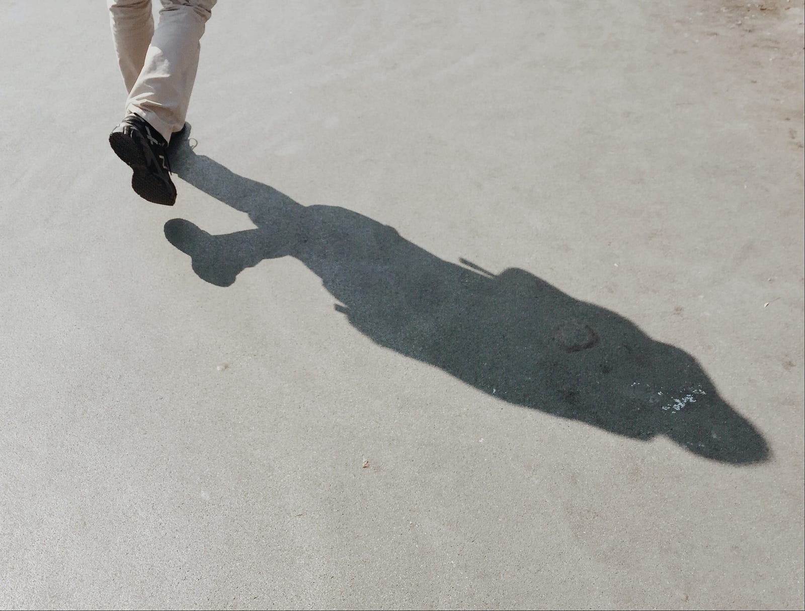 We see a person walking away from us. The image shows the individual in the uppermost left corner. We only see the leg from the calf level down. A shawos course across the rest of the image. The Department of Health and Human Services recommends that we get 150 to 300 minutes a week of moderate physical activity (such as a brisk walk or bike ride), 75 to 150 minutes a week of vigorous physical activity (like jogging), or some combination.
