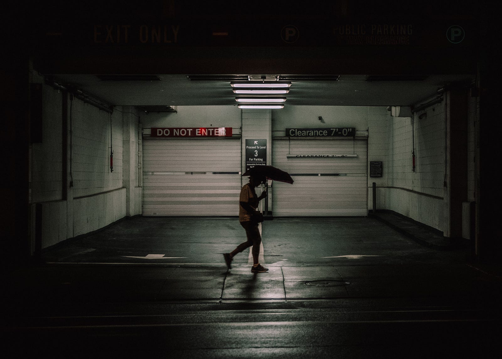A person walks with an umbrella in a fairly dark area. Anxiety disorders can manifest in various forms, such as generalized anxiety disorder (GAD), panic disorder, social anxiety disorder, specific phobias, and post-traumatic stress disorder (PTSD).