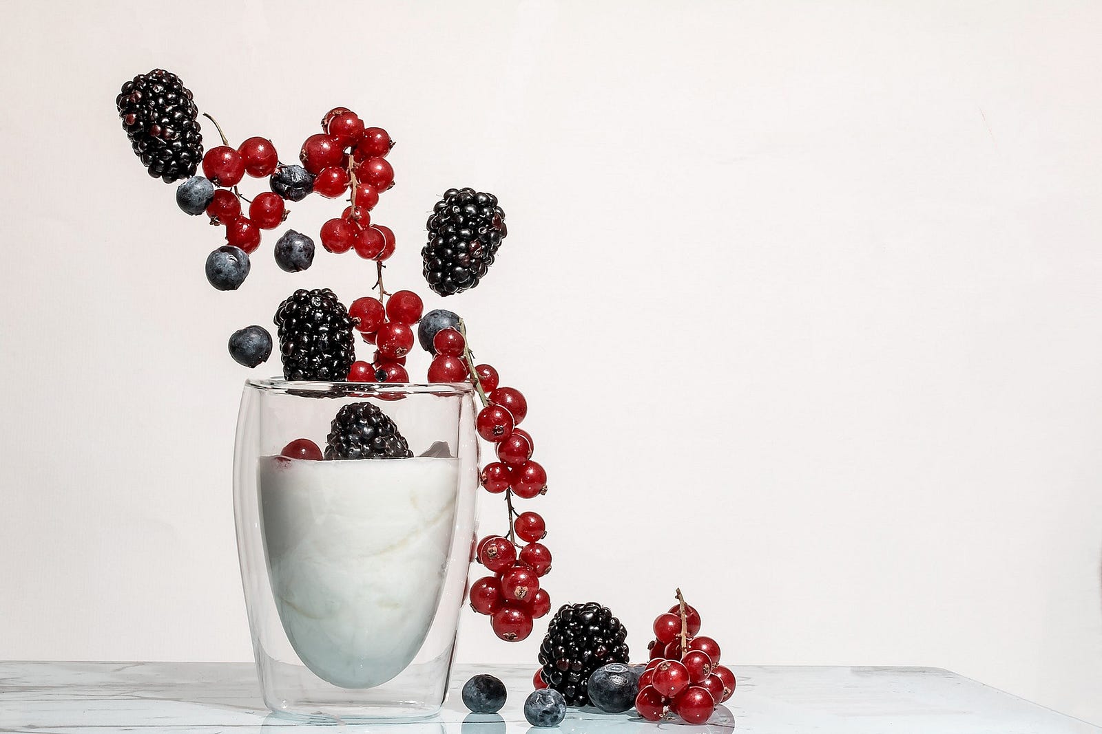 A glass is nearly full of cream, with blackberries and small cherries spilling out of the top of it. Satiation and satiety scores increased for both groups. Waist circumference dropped in both groups. MyPlate, but not calorie counting, resulted in lower systolic blood pressure at six but not at 12 months.