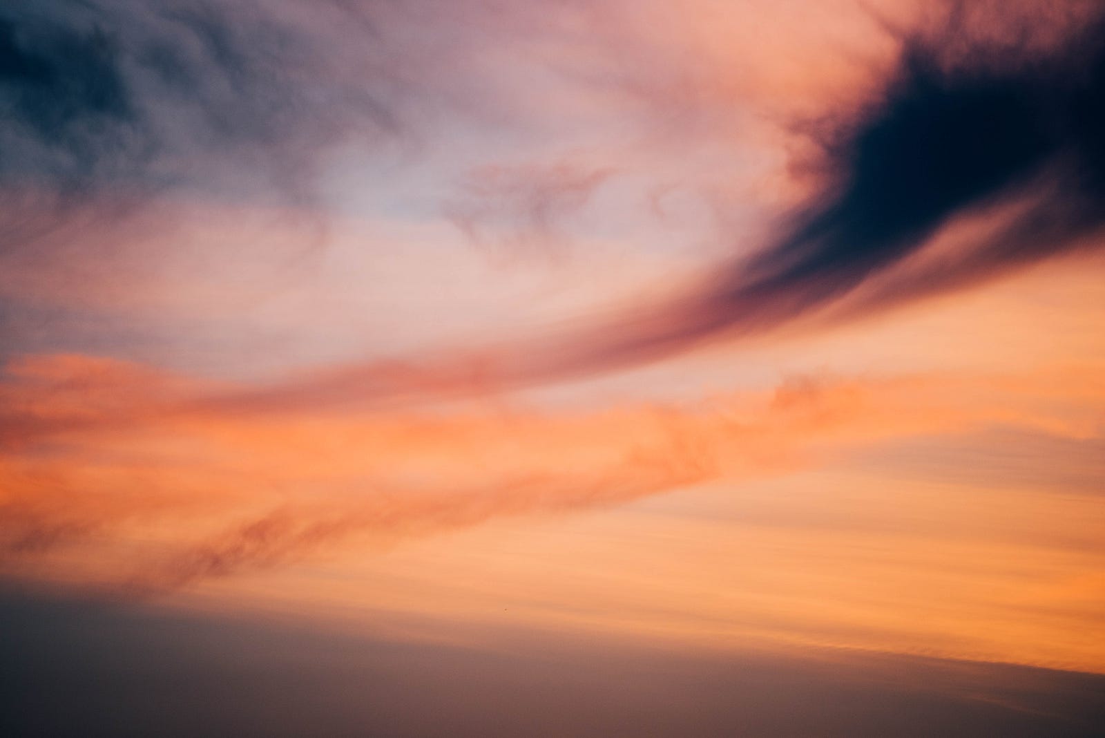 A photo of a surreal sunset, with thin cloud layers cutting diagonally across the image. Chemicals known as free radicals can damage our cells, including our genetic material.