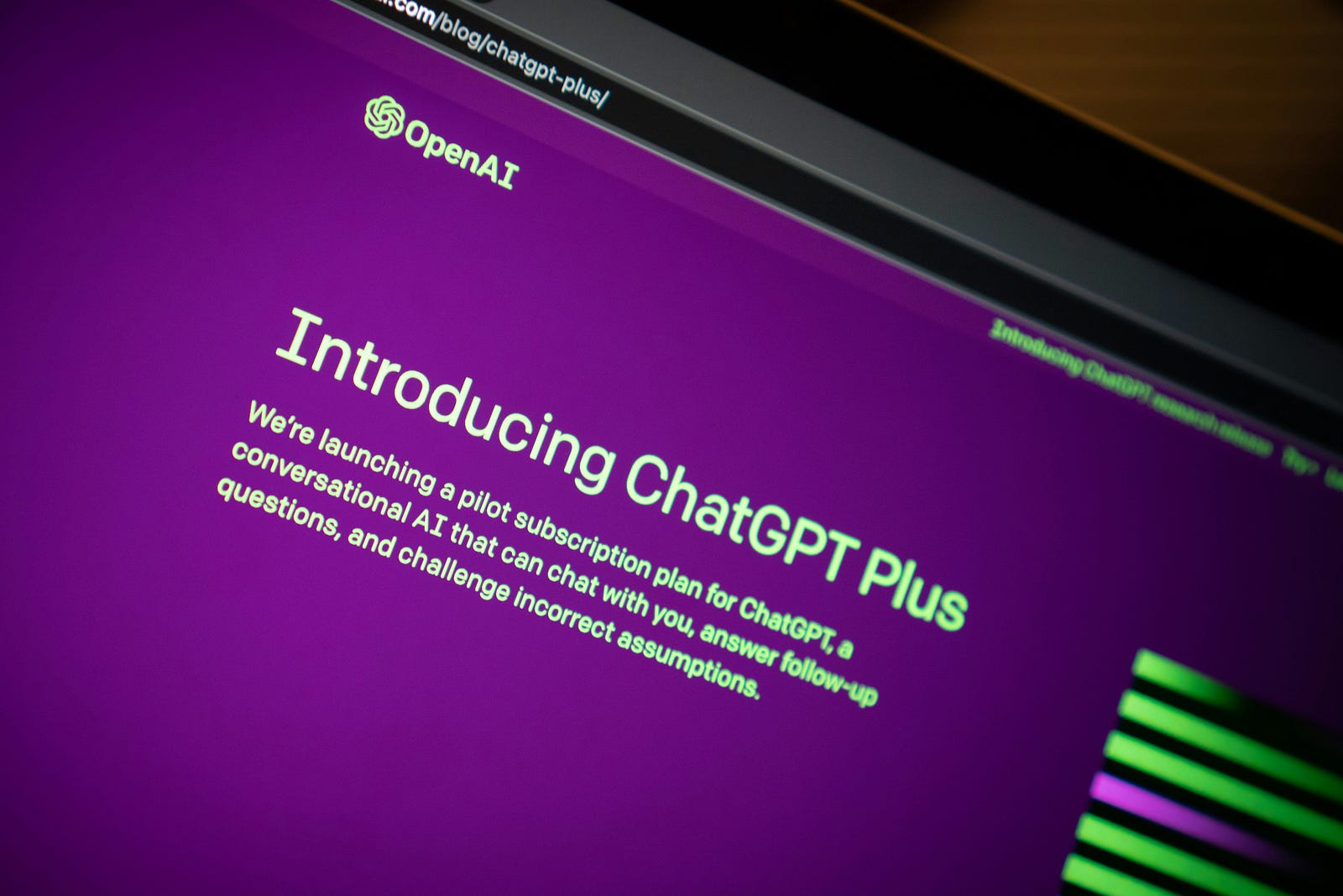 A computer screen reads “Introducing ChatGPT Plus.”