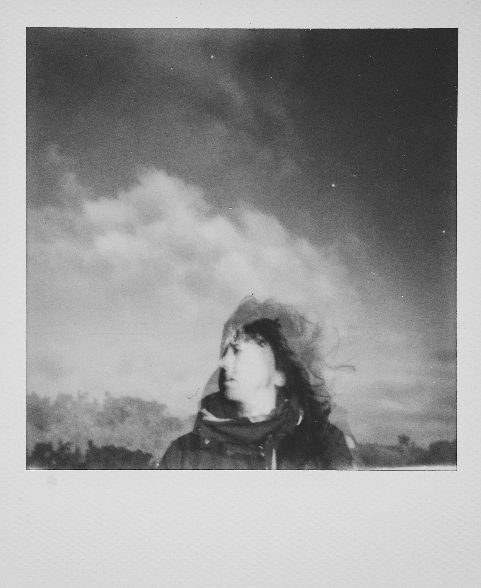 A young woman is blurred in a black and white Polaroid image.