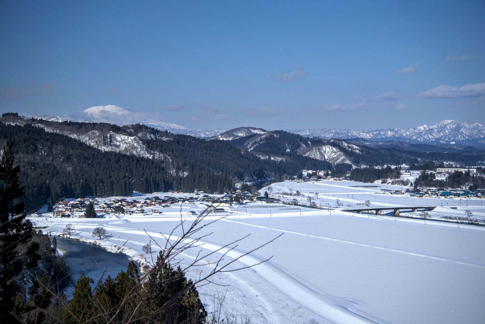 Mt. Chokai seen behind the hills of Sakegawa, rice fields blanketed in snow in the foreground