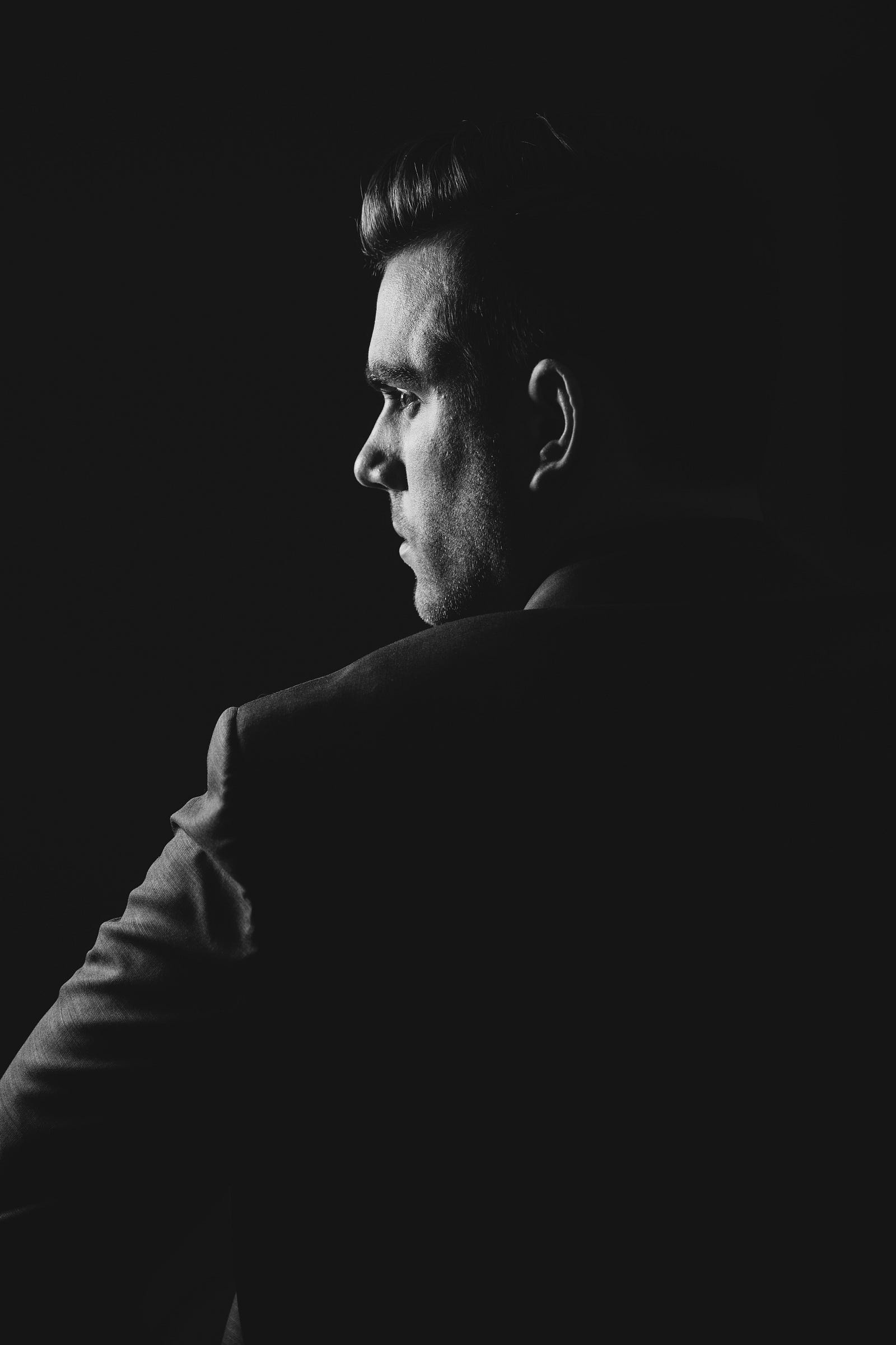 A man looks away in a black and white image.