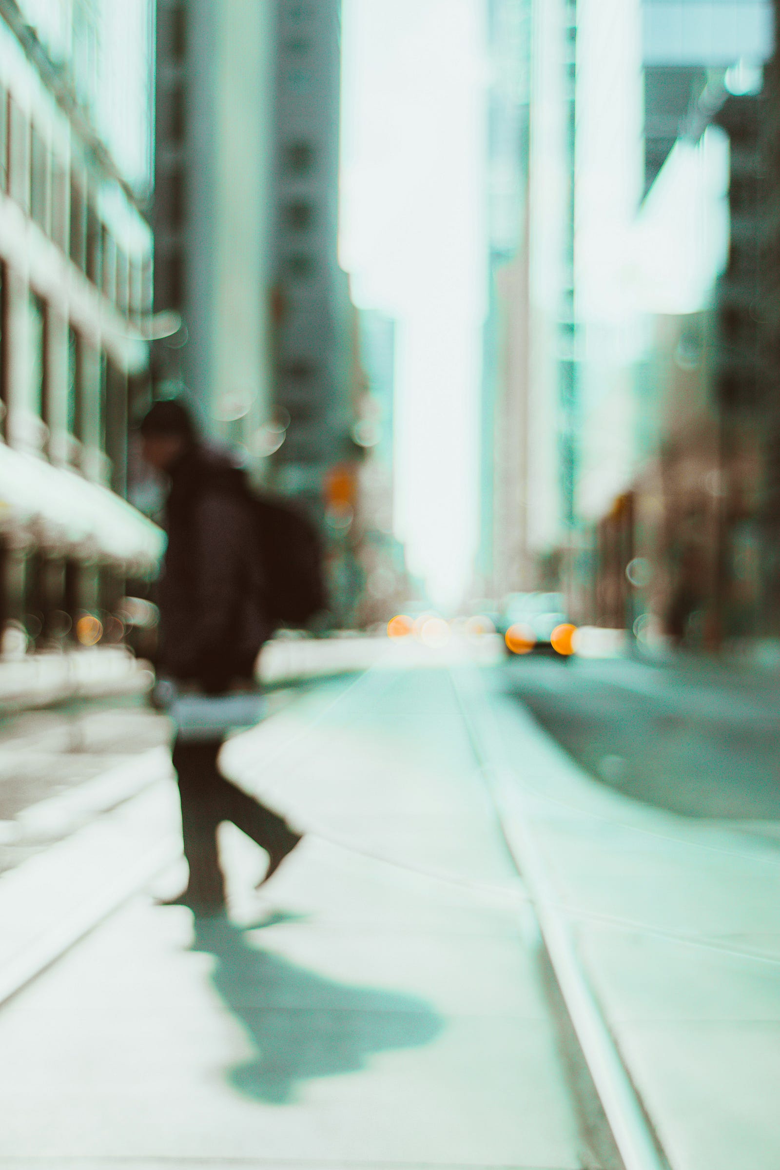 A blurry image of a man crossing a city street. Diabetes can cause blurred vision.