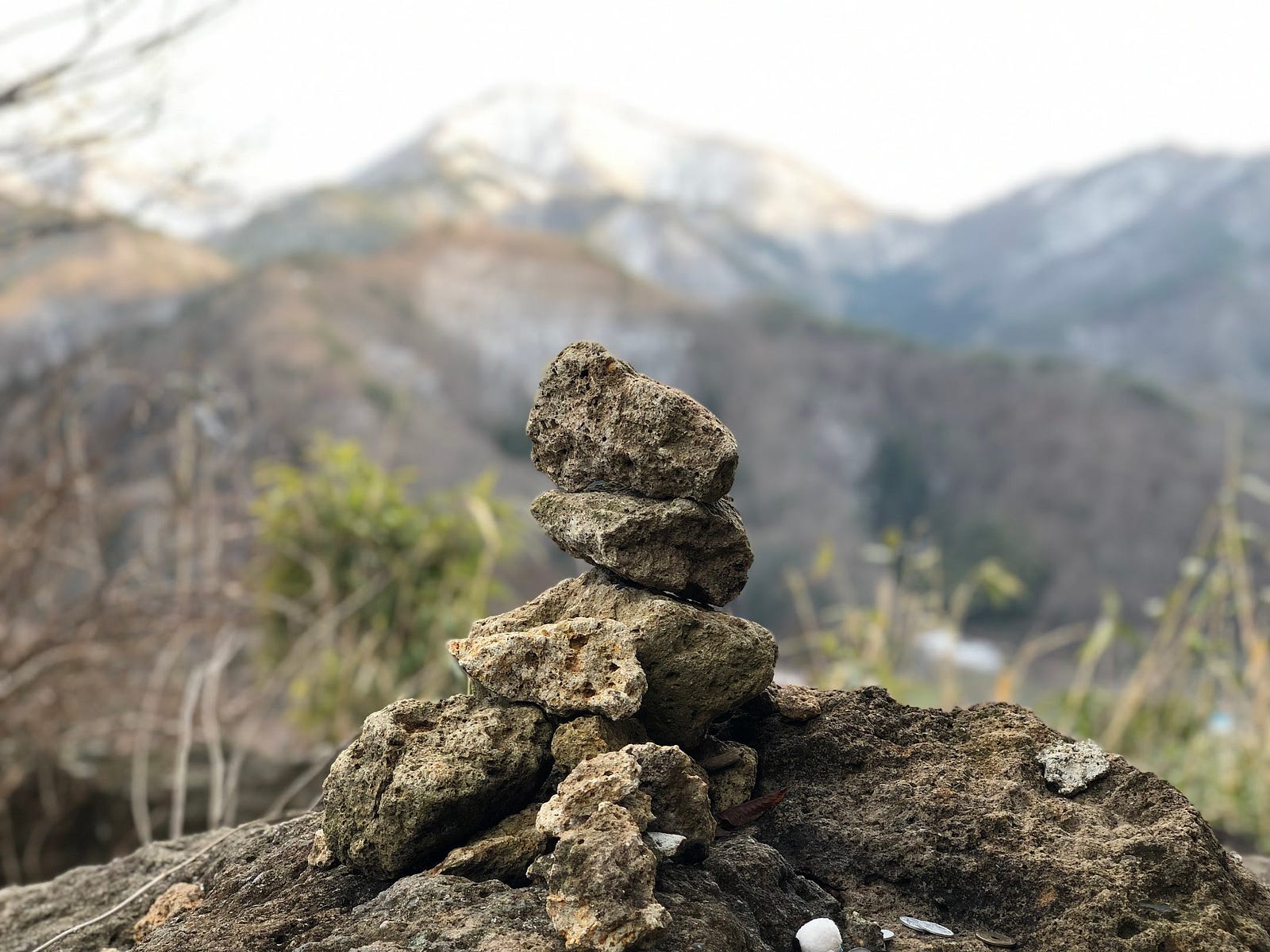 Rocks stacked on top of each other with a mountain in the background. Sights such as these are common in Japan.