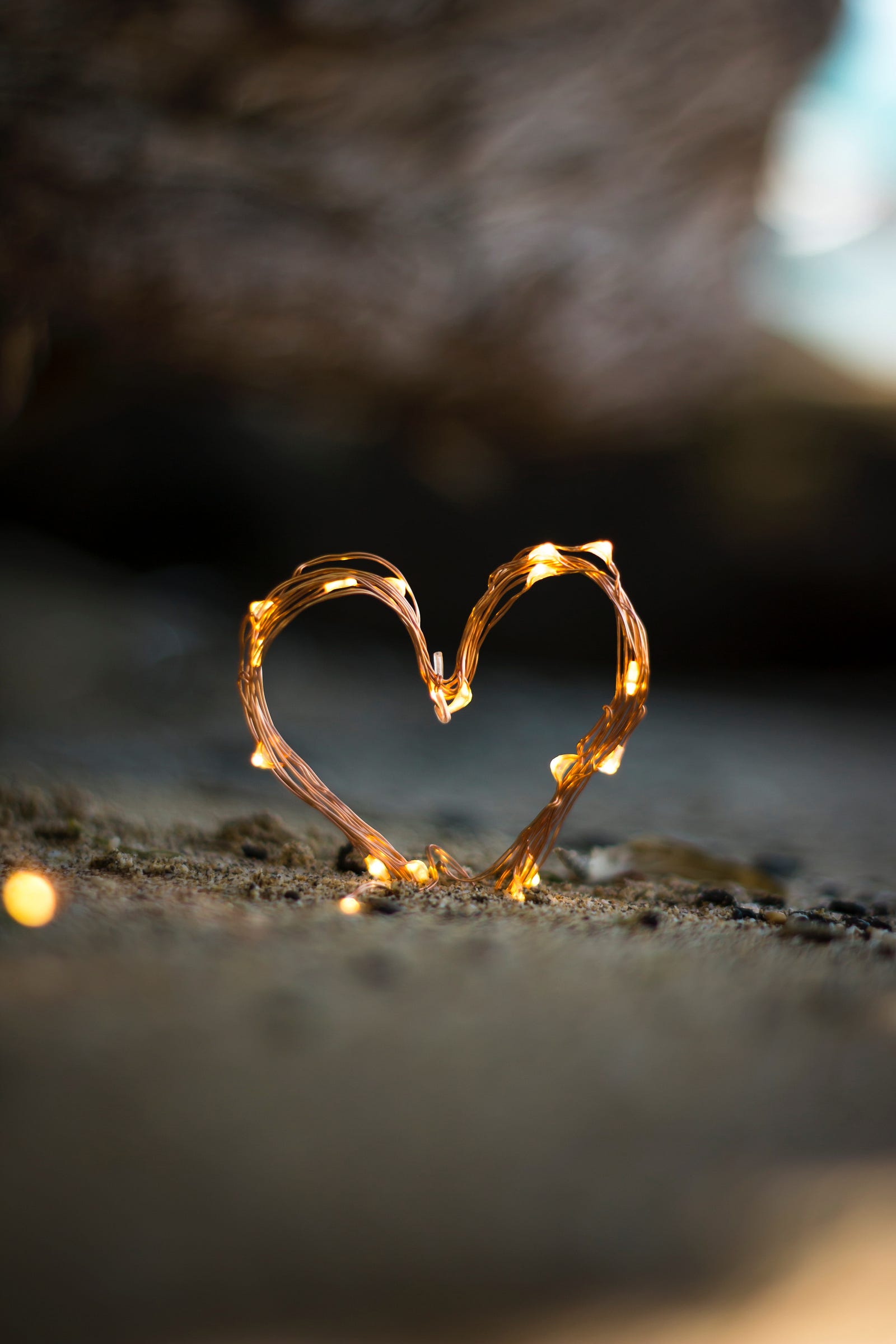 A small heart is made of wires with several tiny yellow lights punctuating it. The heart is sitting slightly in sand. A study published in the American Journal of Epidemiology found that regular participation in non-running aerobic activities, such as swimming or cycling, was associated with a significantly reduced risk of coronary heart disease.