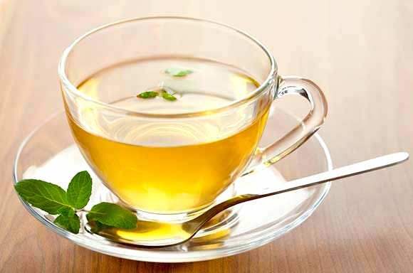 Catnip tea in a tea cup with some leaves
