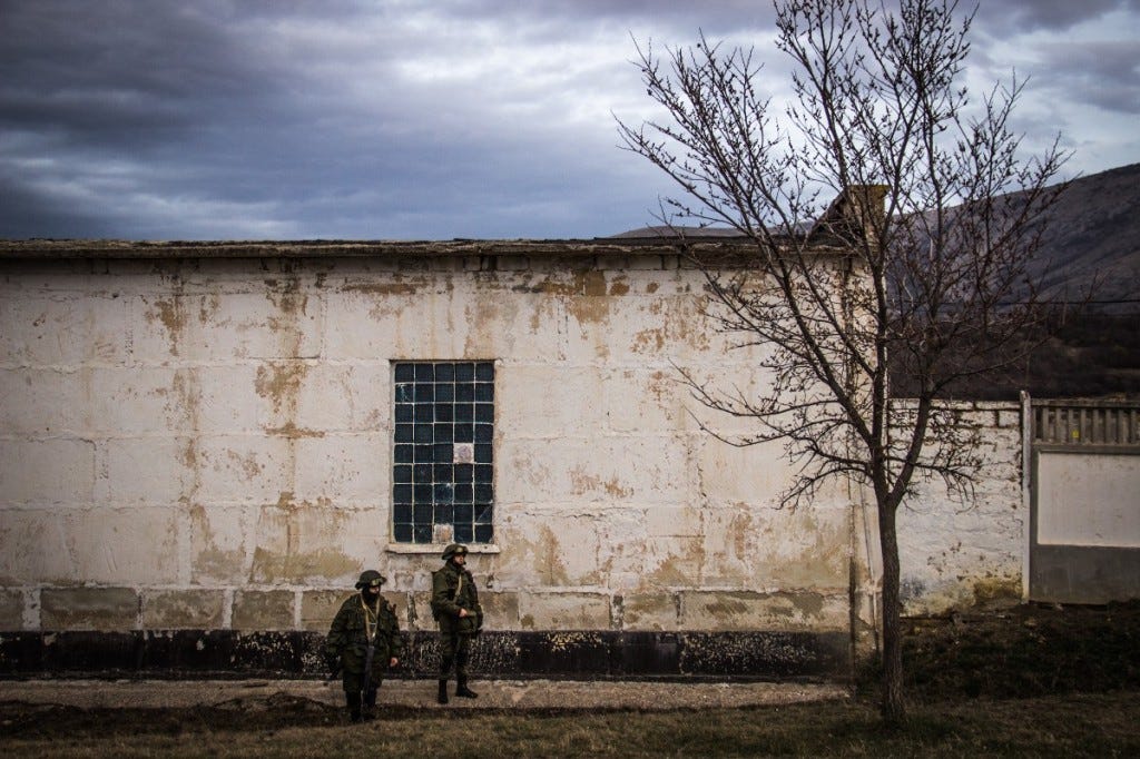 The infamous ‘little green men’ stand guard outside a Ukrainian base at Perevalnoye, Crimea (Noah Sneider)