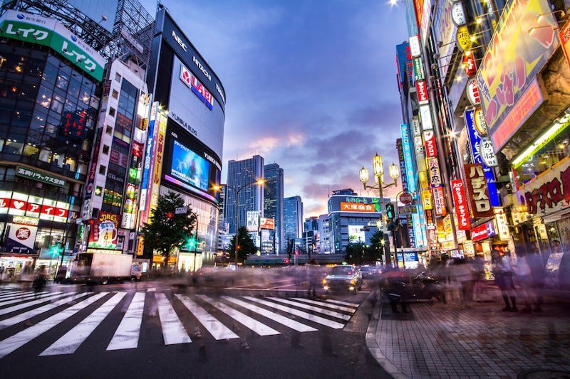 Tokyo’s busy Shinjuku area at dusk as people cross the road