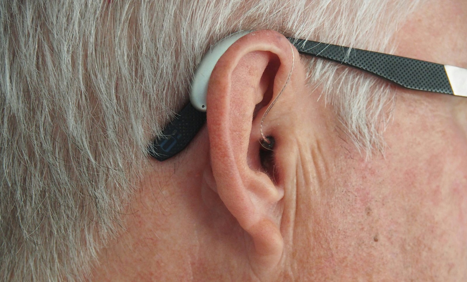 A man wears hearing aids. Hearing loss itself might be an early symptom of dementia.