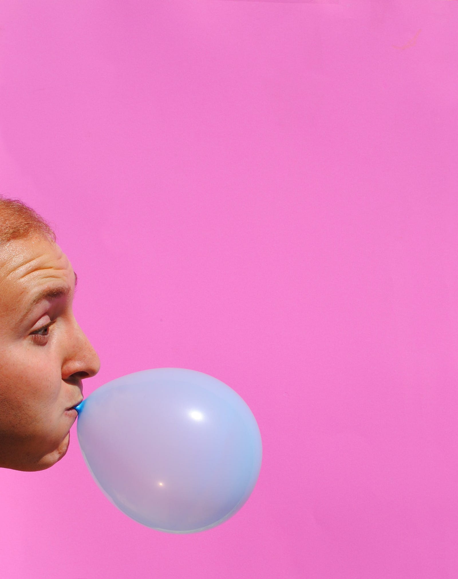 A young man in the lower right corner blows up a blue balloon. One study discovered that individuals who chewed throughout long- and short-term memory tests had better scores than those who did not.