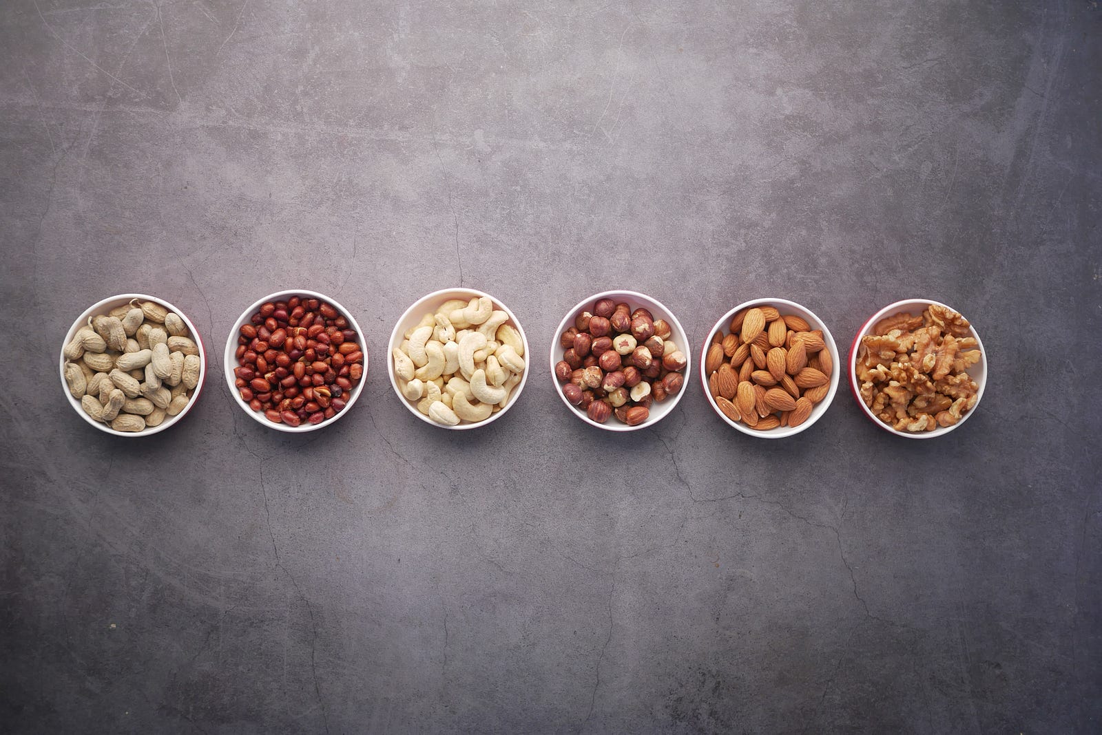 Six small white cups of various nuts. Protein is the undisputed star of muscle building. It provides the essential amino acids your body needs to repair and grow muscle fibers.
