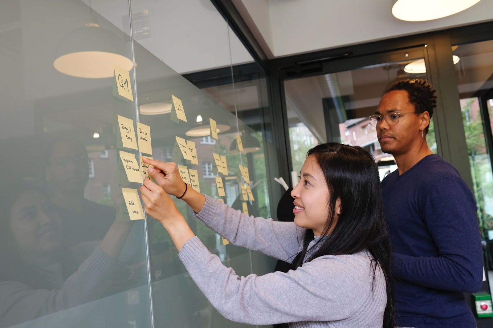 employees pasting post-it notes on a board