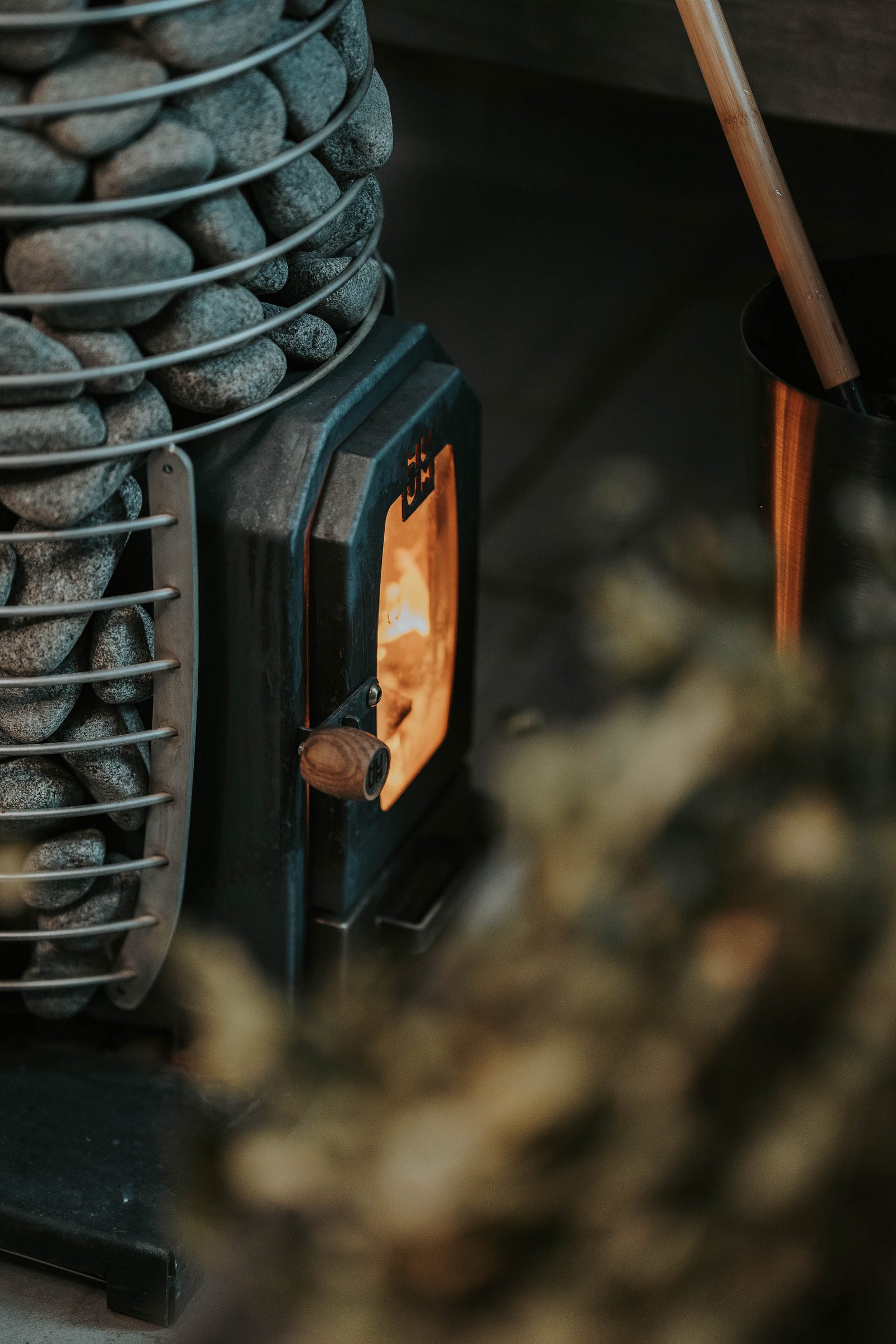 A sauna heater. We seeflames and a container of rocks. Regular sauna use has various benefits, from improved cardiovascular health to stress reduction.