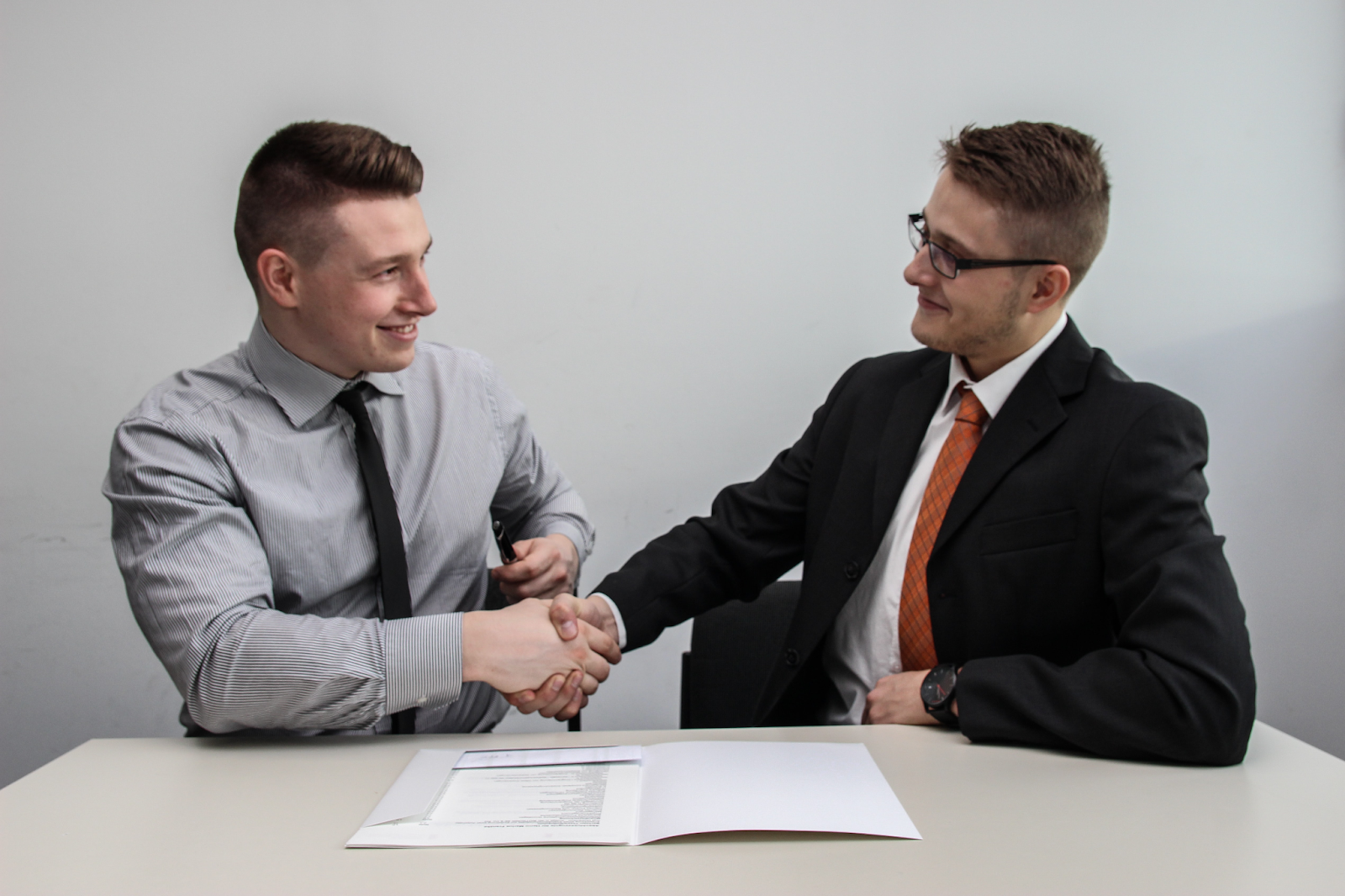 two employees agreeing on something through a handshake turnover