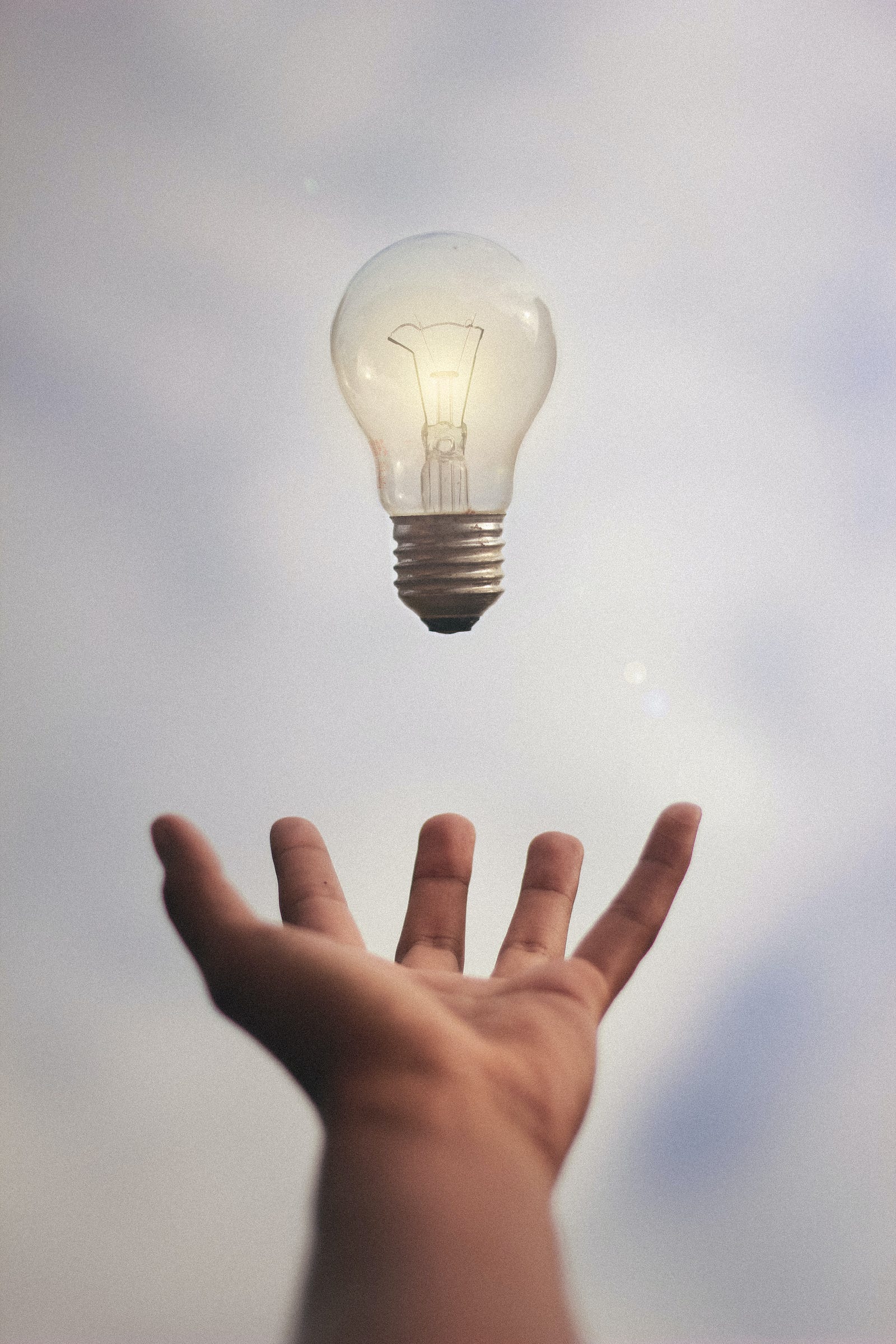 A hand tosses a lightbulb into the air. Lux is a measure of illumination. It varies with the distance to the light source.