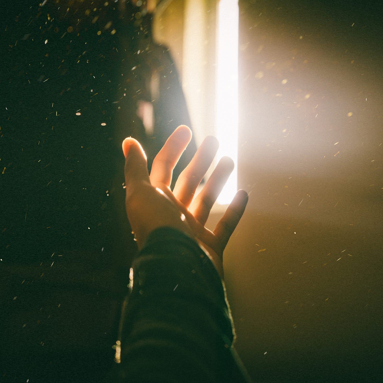A hand reaches towards a thick ribbon of light. Depending on the treated condition, phototherapy can be delivered using different light sources, such as light boxes, lasers, and UV lamps.