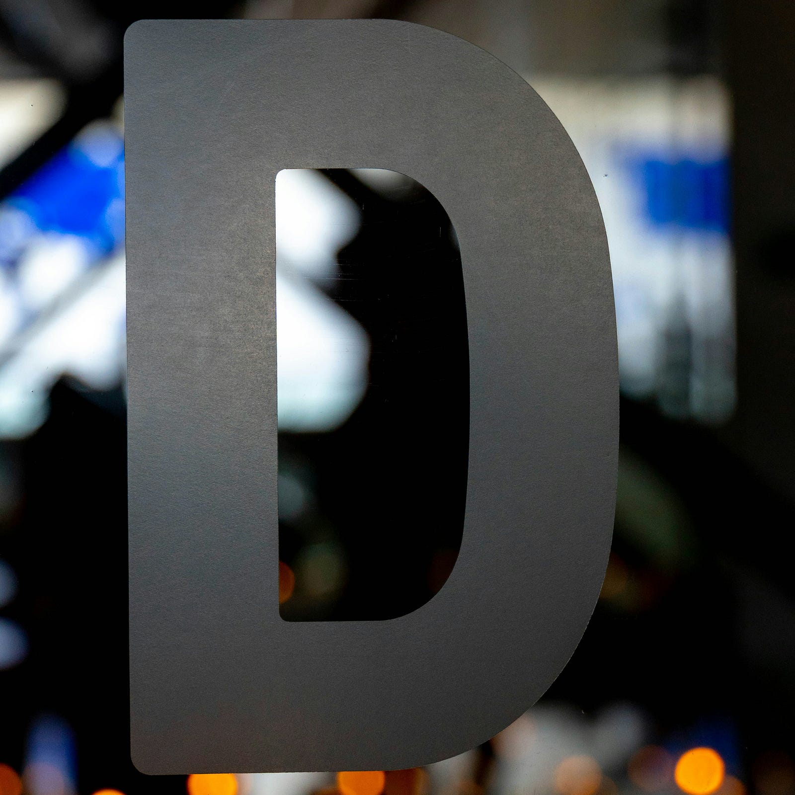 A gray capital letter “D.”