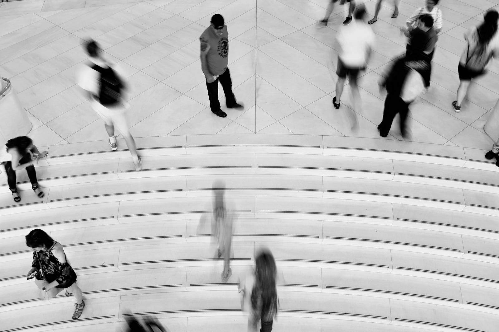 A dozen people mill about on a wide flight of stairs. Black and white image with photo shot from above. Compared to my usual brisk walking, stair climbing is an enhanced aerobic activity; there’s the muscle activation associated with usual walking, plus I engage other muscles during climbing.