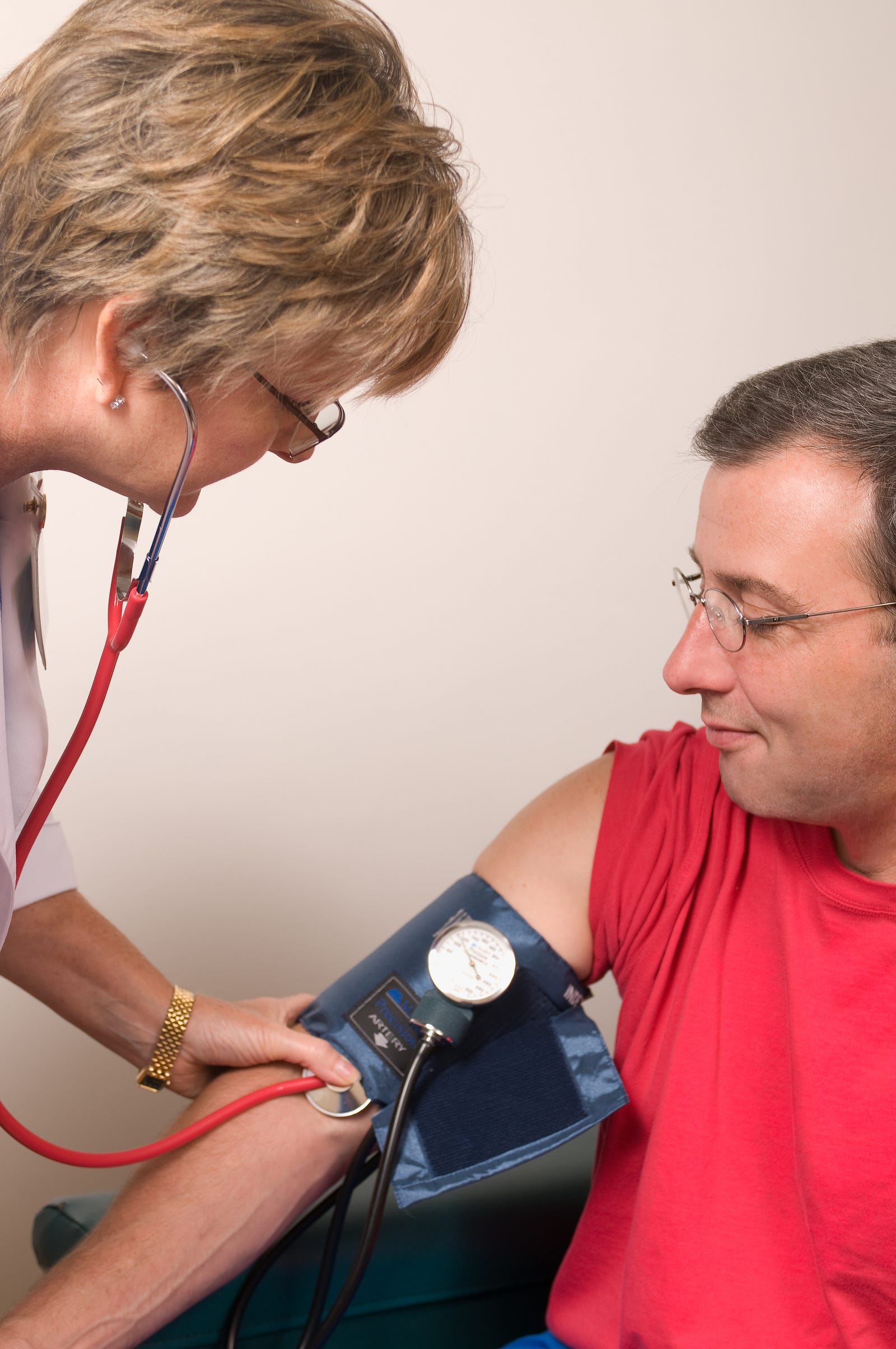 A woman check’s a man’s blood pressure. Mindfulness is associated with a lower blood pressure.