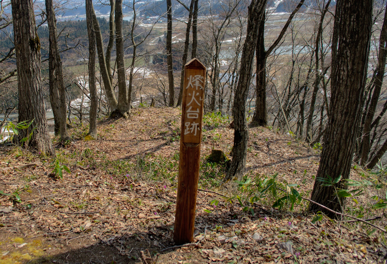 A post in the foreground signifying the location where Mt. Yamuki’s smoke signals were made.