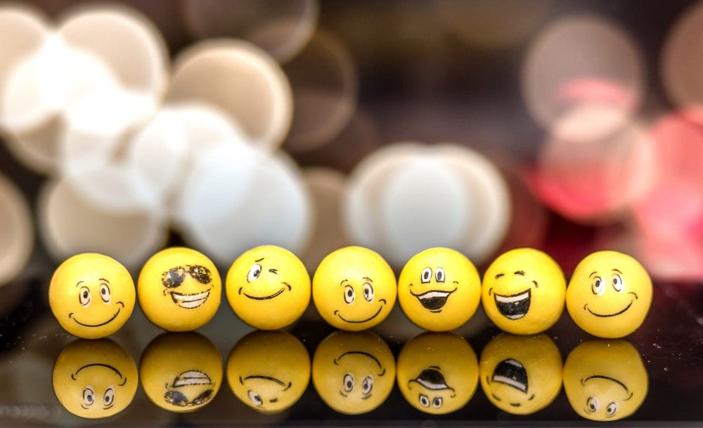 A surface with spheres with different smiling faces painted on them. 