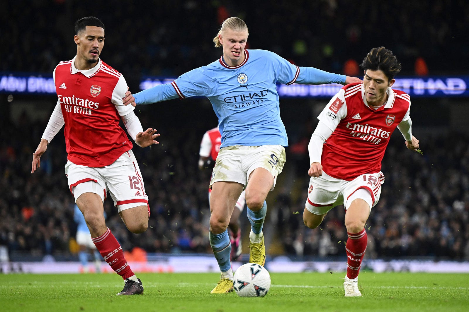 Erling Haaland squaring up agains William Saliba and Takehiro Tomiyasu