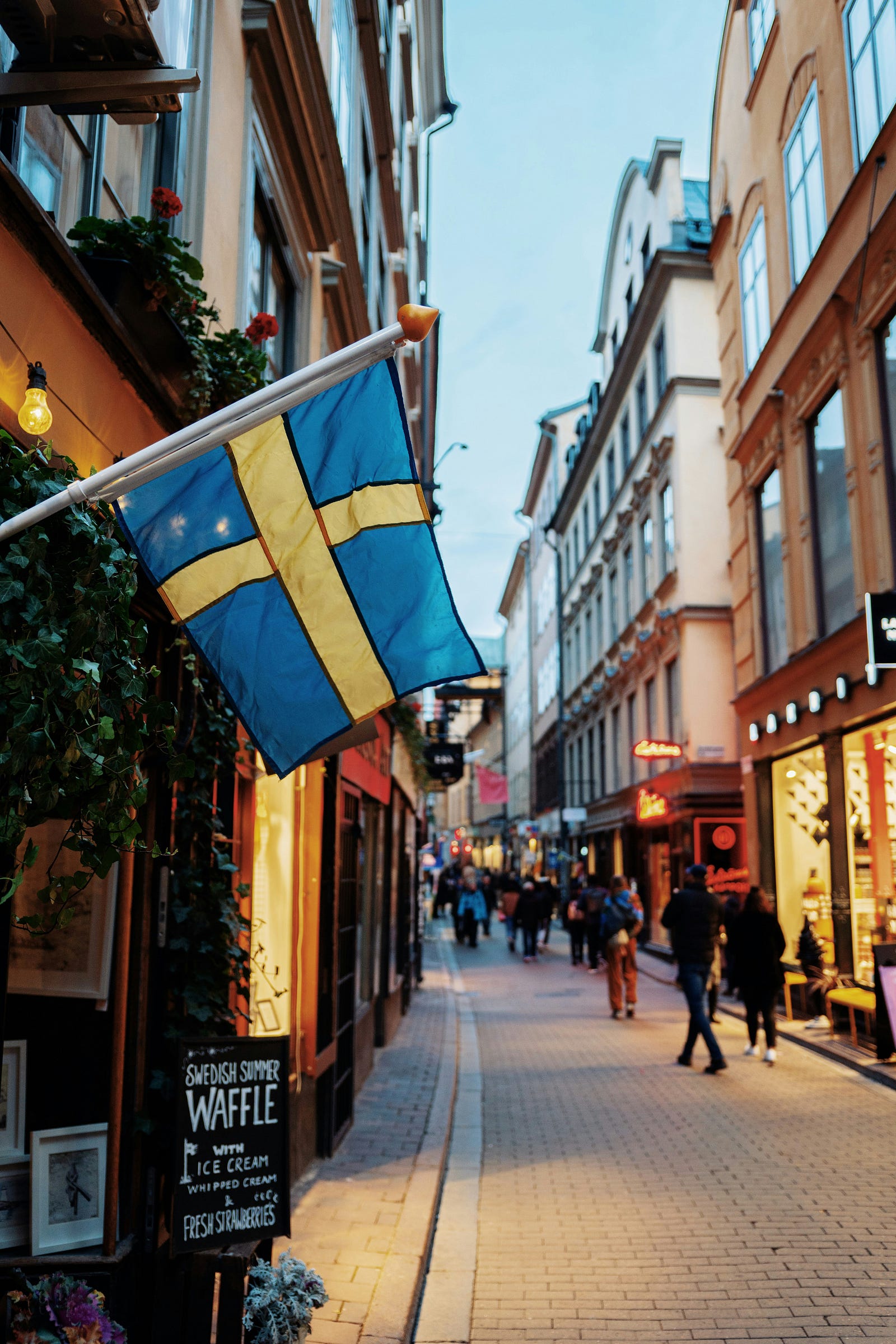 A street scence in Gothenburg (Sweden), the Swedis flag hangin off a building in the foreground.