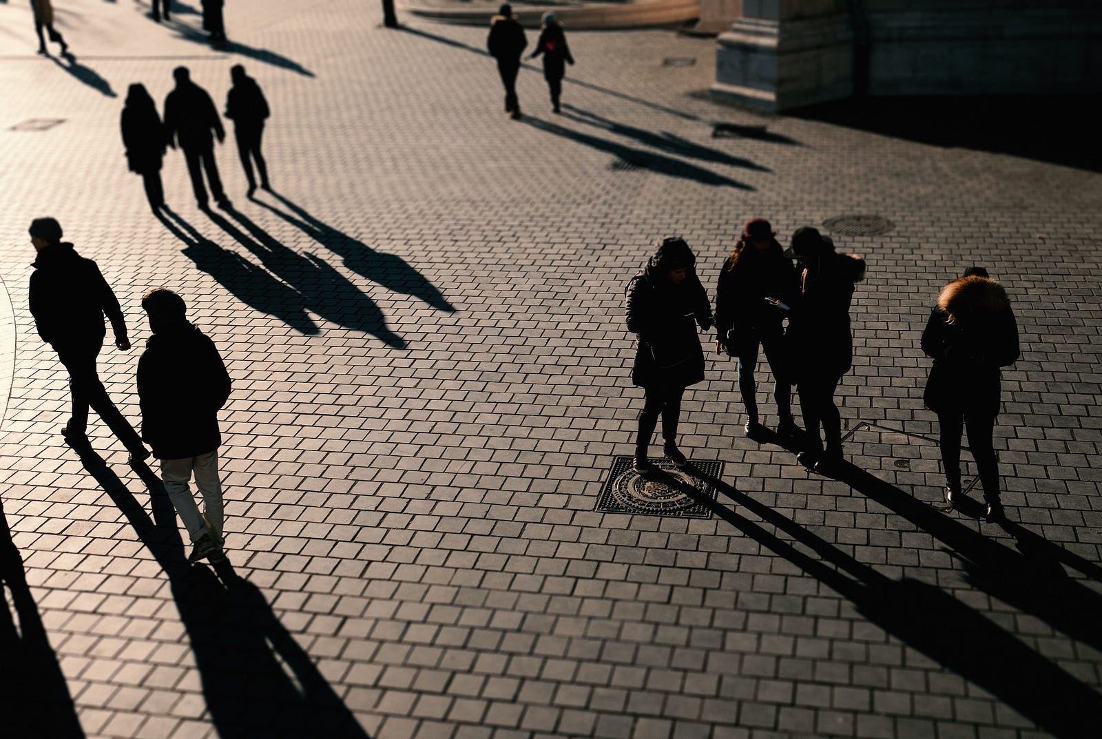 Balck and white image of several people walking in a town square. If people took a short walk after eating, their blood sugar levels rose and fell more gradually. Moreover, their insulin levels were more stable than either standing or sitting.