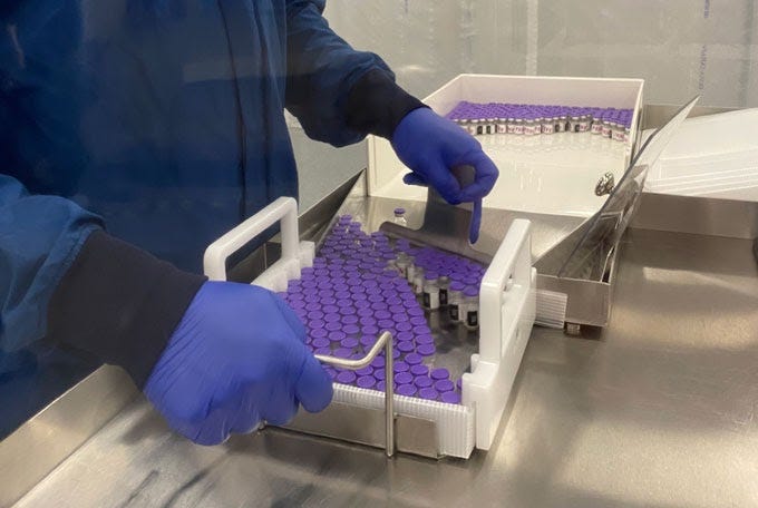 A worker loads vials of Pfizer and BioNTech’s COVID-19 vaccine into specialized containers, nicknamed pizza boxes, which are charged with dry ice to keep the vaccines at –70 °C for transport and short-term storage (Source: ScienceNews.org)
