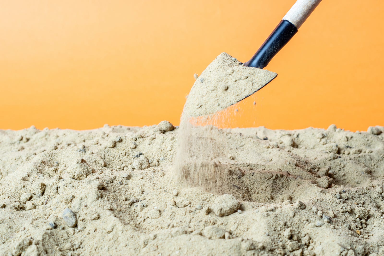 A shovel digging up a scoop of sand