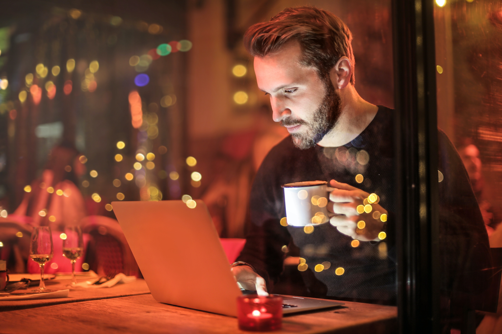 man working on laptop and drinking coffee with time tracking app