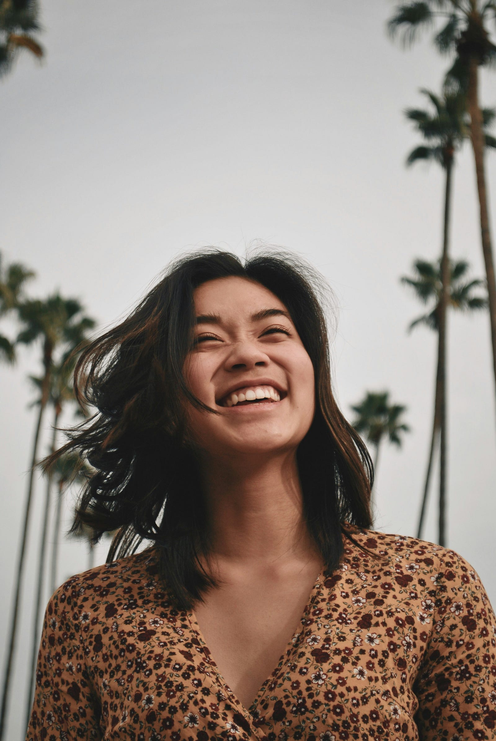 A young Asian woman laughs. There are palm trees on either side of her. The U.S. Preventive Services Task Force (USPSTF) recommends the following cervix cancer screening: Women 21 to 65: Screen with cytology (Pap smear) every three years. Women 30 to 65: Screen with cytology (Pap smear) every three years or co-testing (cytology/HPV testing) every five years.