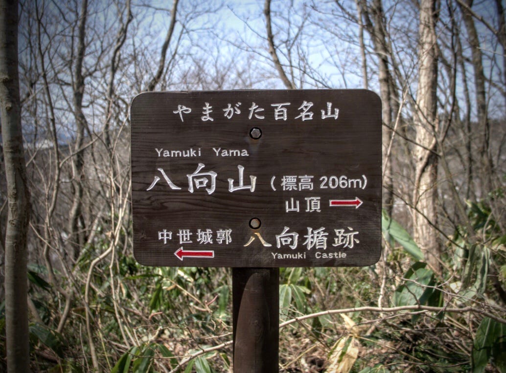 A sign pointing to the summit of Yamuki-yama and the remains of the Yamuki Castle along the Mogami River in Yamagata Prefecture