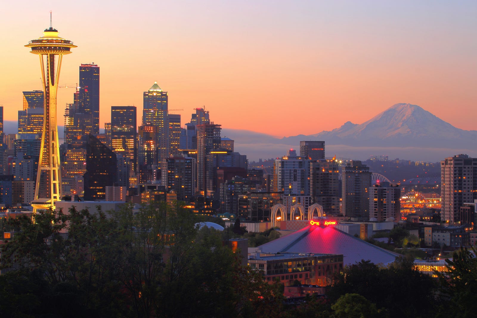 Seattle landscape at sunset. The Space Needle is in the foreground and Mount Ranier in the rear (on the right). Running in nature can drop stress hormone levels.