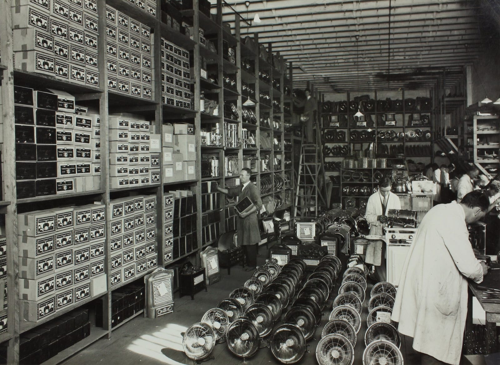 A black and white image of a small historical factory. Kaizen encourages input from any employee. One can be a factory worker or a C-suite member and contribute.