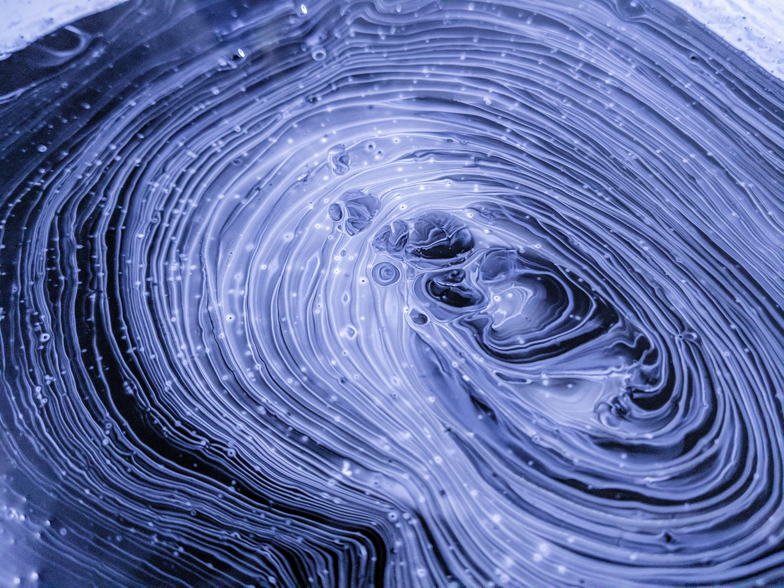 Ab abstract image of a pattern that looks like tree rings, but with white fibers curling in space.